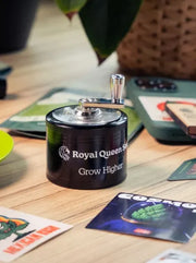 Royal Queen Seeds Grinder auf Tisch im Einsatz hochwertiger Metall Kräutergrinder Zubehör Lifestyle Aufnahme