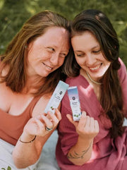 Zwei Frauen halten H4CBD Vape Verpackungen von Hemnia im Freien